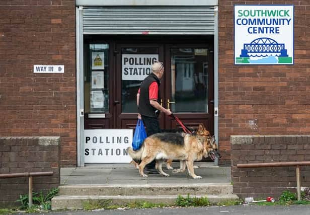 Man takes a dog to a polling station