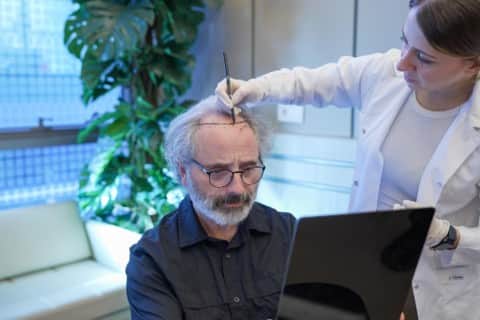 Dr. Busra Yakupoglu designing a hairline on a patient before surgery