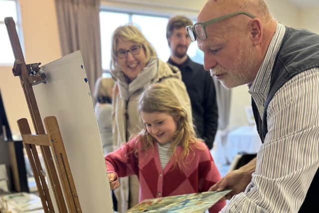 Artist Kevin Nicholls helping visitors to have a go at painting