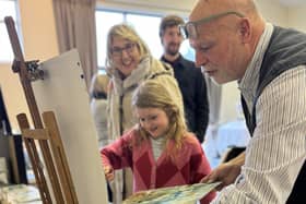 Artist Kevin Nicholls helping visitors to have a go at painting