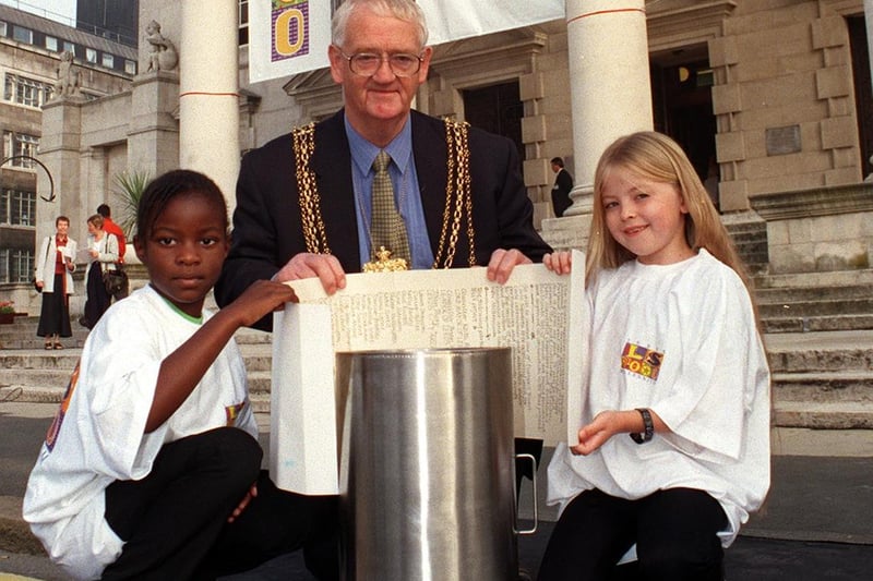 The Lord Mayor of Leeds and two members of Leeds Drama Umbrella -  Tamara Atieno (left) and Ezra Tren-Humphries - put a millennium scroll into a time capsule outside Leeds Civic Hall.