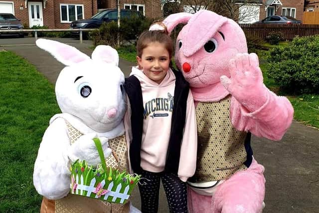 The Easter bunnies with one of the children living on the estate while doing their rounds.