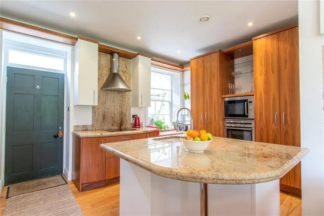 The beautifully designed open-plan kitchen has granite worktops and central island.
