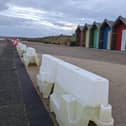 Plastic barriers have been placed along the promenade to warn of the sheer drop off since winter. (Photo by National World)