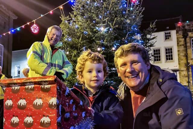James Abercrombie, with his dad, Richard, switched on Alnwick's Christmas lights in 2020, watched by lights committee chairman Gordon Castle.