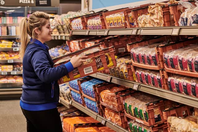 An Aldi staff member stocks the bread shelves at one of their stores.