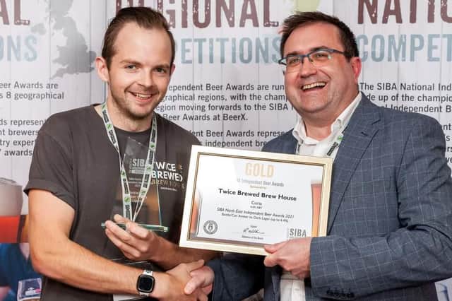 Twice Brewed Brew House's head brewer, Matthew Brown accepts the gold award for Coria.
