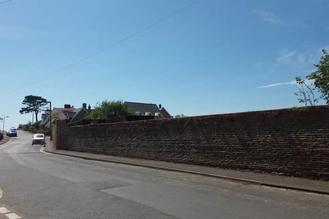 The shipping containers are visible over the top of the walled garden in Bamburgh.