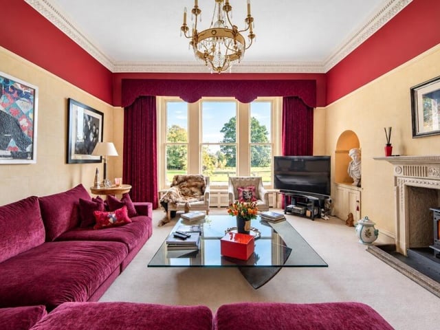 A living room with period fireplace and views across the gardens.