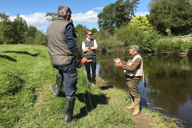 The Duke of Northumberland talking to instructor Bob Smith and one of the participants of the 'try river fishing' event.