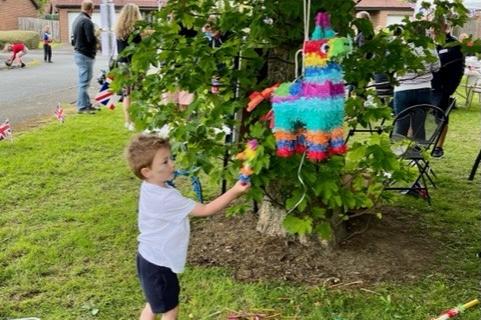 A youngster has a go at retrieving goodies from a pinata.