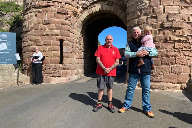 Postman Vince Knox with castle owner Francis Watson Armstrong with one of the youngest members of the family - granddaughter Poppy Ziemelis.