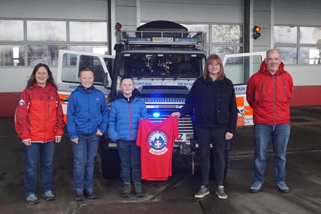 Henry and Ewan receive their T-shirts from Andrew and Andrea Wilson (Operational Team Members) and Laura Kennedy (Support Team Coordinator).