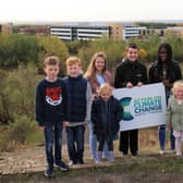 Young people holding the council’s new Action on Climate Change logo, which will be launched during COP26, in Silverlink Biodiversity Park.