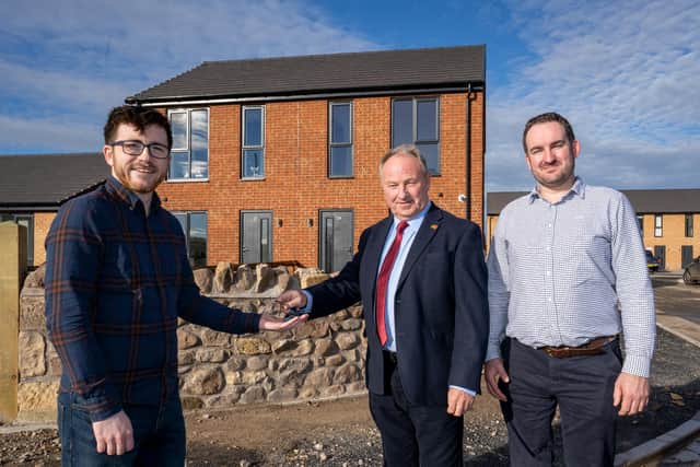 James receives the keys to his new Wooler home from Cllr Colin Horncastle, with Cllr Mark Mather looking on.