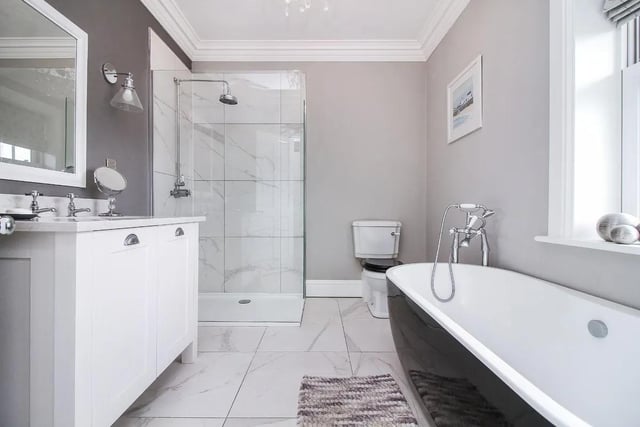 The main family bathroom features custom panelling and free-standing bathtub.