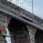 Engineers repairing the Royal Border Bridge using a rope access system.