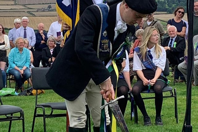 The Coldstreamer cuts a sod of earth from Flodden Field to take back to Coldstream.