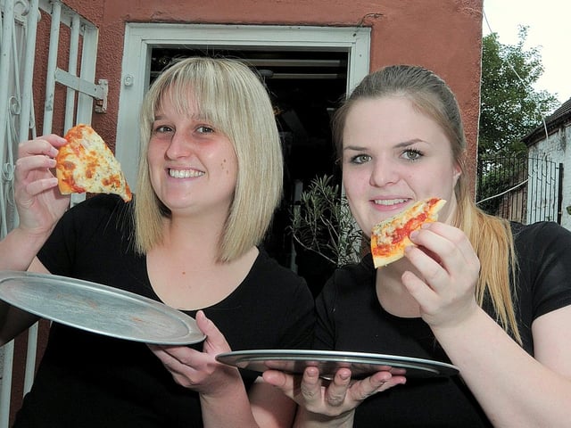 Olive Grove staff members  Meggan Gambles (left) and Ashlie Mellott show off some of the free pizza slices on offer during buffet nights back in 2014