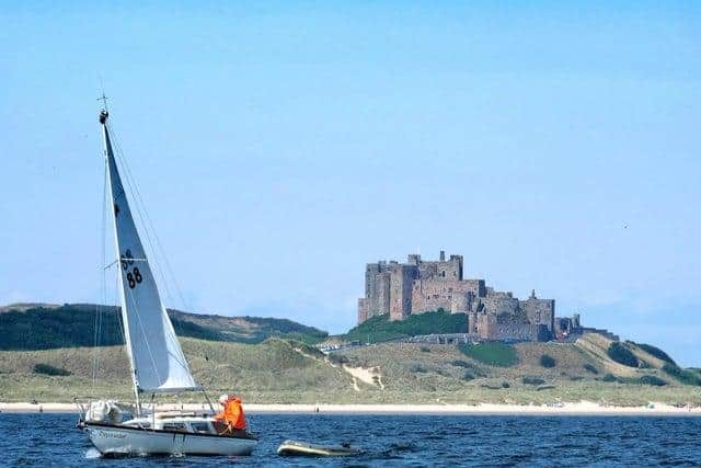 A yacht glides by Bamburgh Castle. Picture by Jane Coltman