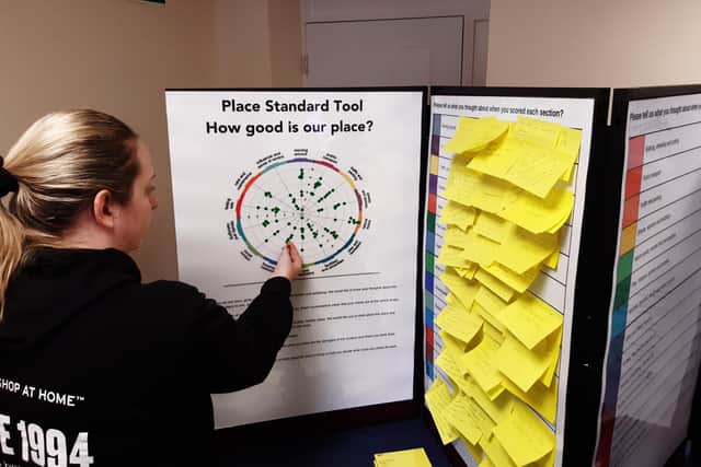 An event attendee contributing to the Place Standard tool. They are applying a sticky dot to indicate how much they approve or disapprove of certain elements of Bedlington.