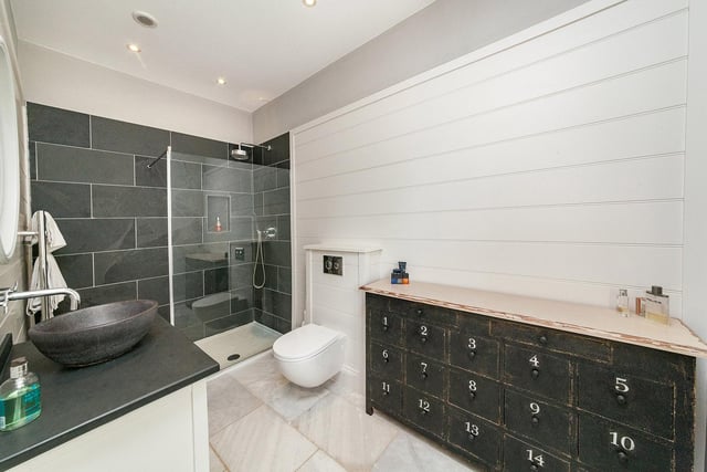 This modern en-suite shower room transitions nicely from a dressing room and comes with a walk-in shower, wash basin and WC.