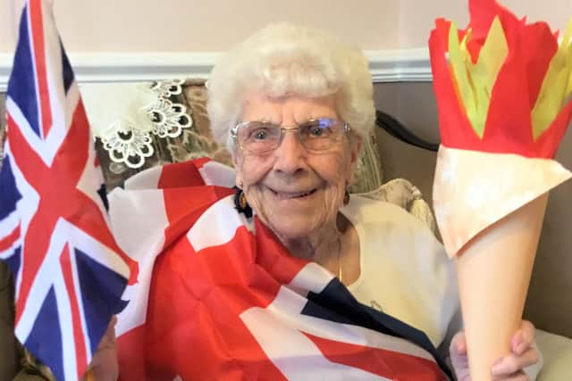 Resident Doreen Wilkinson with her homemade Olympic torch.