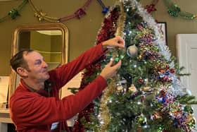 Robert Thompson puts up Patricia's tree, with vertical hanging tinsel which Patricia favoured. Picture courtesy of the National Trust.