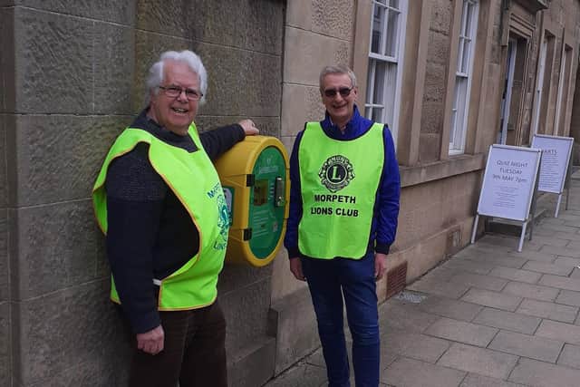Morpeth Lions Les Sage and Peter Crook next to the new defibrillator.