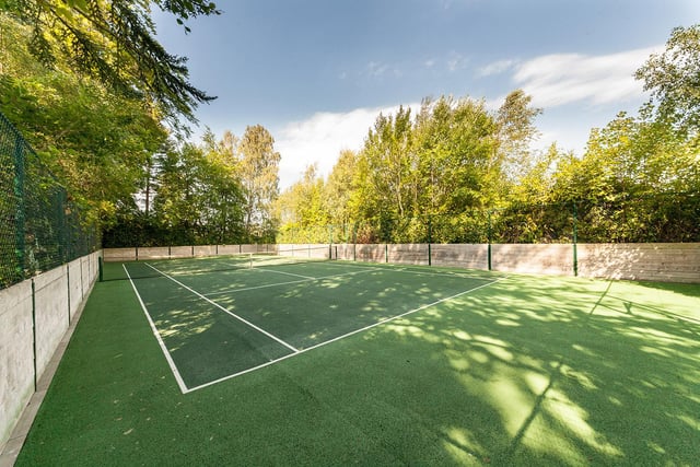 To the front of the property is the all-weather tennis court with a further seating area located off.