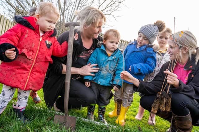 Nursery manager Janine Bainbridge and nurser carer Abbie Balmbra planting trees with the children.