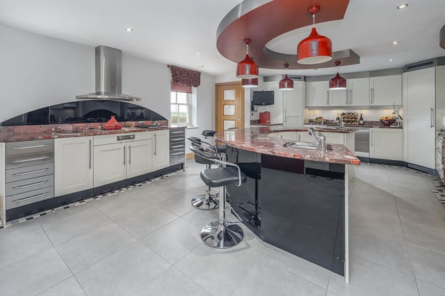 The fully fitted kitchen is particularly impressive with a central crescent shaped island ideal for entertaining.