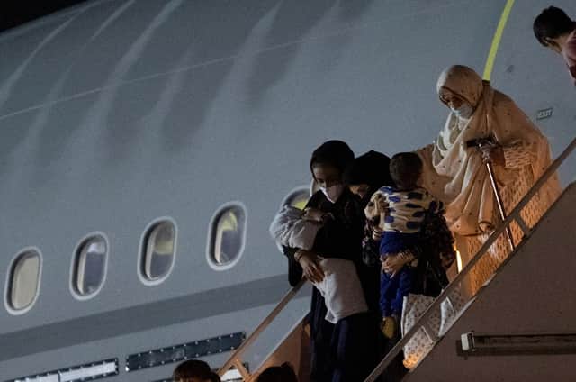 Passengers evacuated from Afghanistan disembark from a British Royal Air Force (RAF) Airbus aircraft, after landing at RAF Brize Norton on August 24, 2021. (Photo by Justin Tallis/AFP via Getty Images)