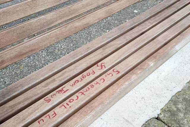 The racist and anti-Semitic graffiti on the memorial bench.