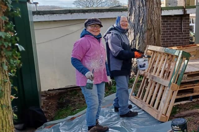 Friends of Castle Parks volunteers Julia and Enid paint reclaimed pallets for the new composting scheme in Castle Vale Park.
