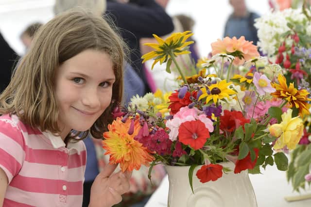 Poppy Rudge admires some of the blooms at Etal Show. Picture by Jane Coltman