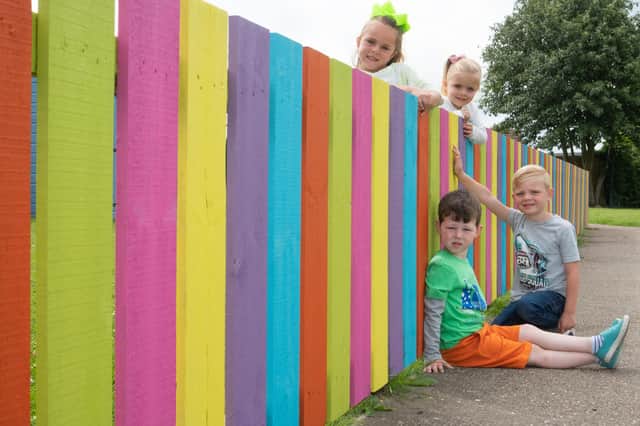 St Bede's RC Primary students next to their newly painted fence at Nursery.