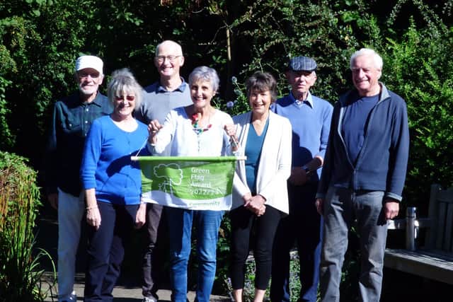Some of the trustees celebrate another Community Green Flag, with chairman Val Stevens holding the flag.