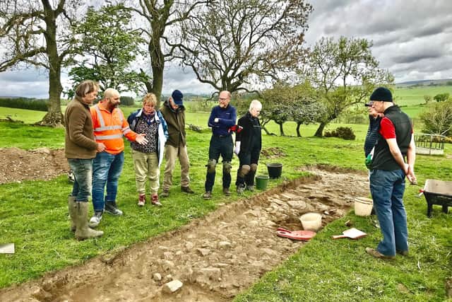 Gareth Williams of Tarmac Harden with archaeologist, Richard Carlton, at a Roman Road section plus some of the diggers.