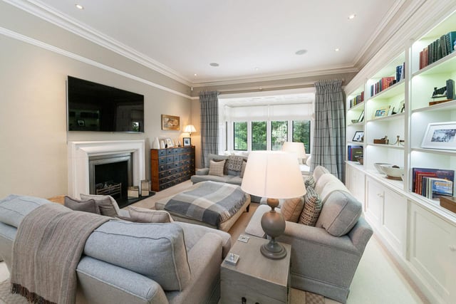 The sitting room provides more informal relaxation with built in display shelving and cabinetry and a living flame gas fire with contemporary fire surround.
