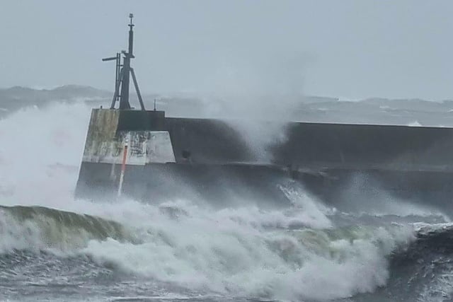 Waves crashing into Seahouses harbour.