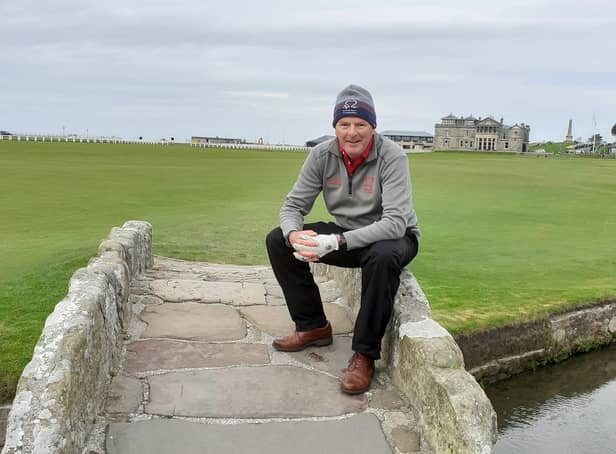 Alistair Collin pictured sitting on the Swilcan Bridge on the Old Course at St Andrews.