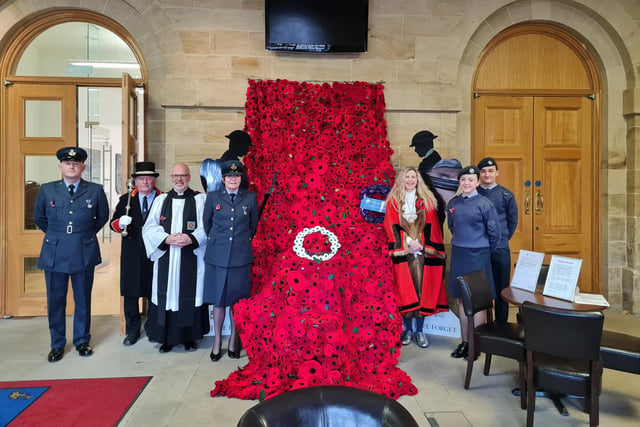 The poppy cascade in the Town Hall being admired on Armistice Day.