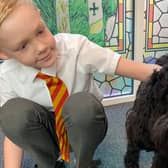 Mac the dog with a pupil at St Bede's Catholic Primary in Bedlington.