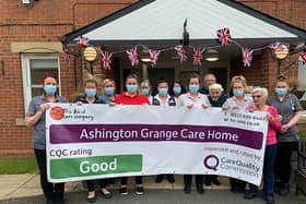 Staff at Ashington Grange Care Home hold up a banner showing their 'good' CQC report.