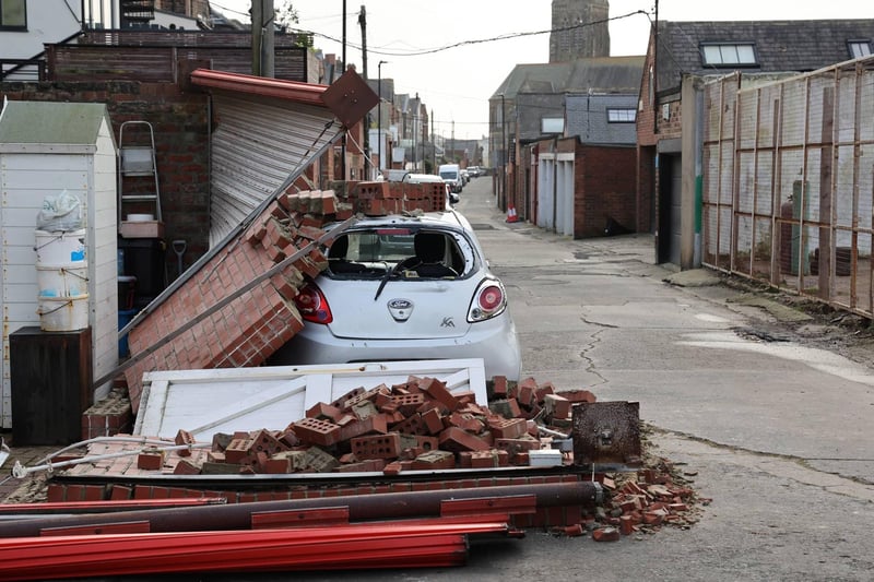 A car stands under a pile of bricks after a wall collapsed onto the vehicle overnight.