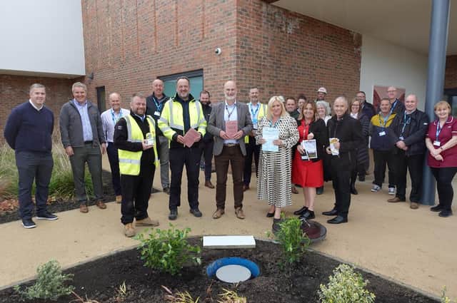 Staff from CNTW, NTW Solutions, and SRM gather to celebrate the time capsule. Front row left to right, each holding items to be placed in the capsule: Tom Senior, SRM Chief Engineer; Steve Naylor, CEDAR Programme Director; James Duncan, Chief Executive at CNTW; Tracey Sopp, Managing Director at NTW Solutions; Sandra Barker, Associate Nurse Director for Secure Care services at CNTW; and Dennis Davison, Associate Director for Secure Care services at CNTW.