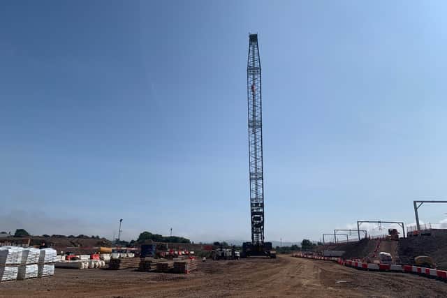 A crane lifting concrete platform sections into position.