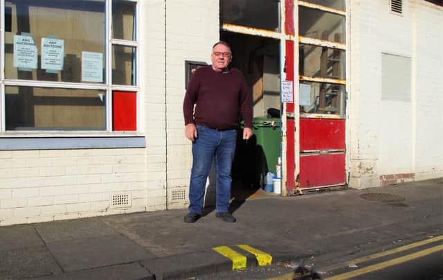 Gary Coxon, a partner in ADG Auctions, with the new parking restrictions outside his premises.