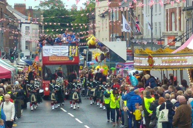 Hundreds of people line the streets to cheer on Morpeth Town FC's open top bus parade.